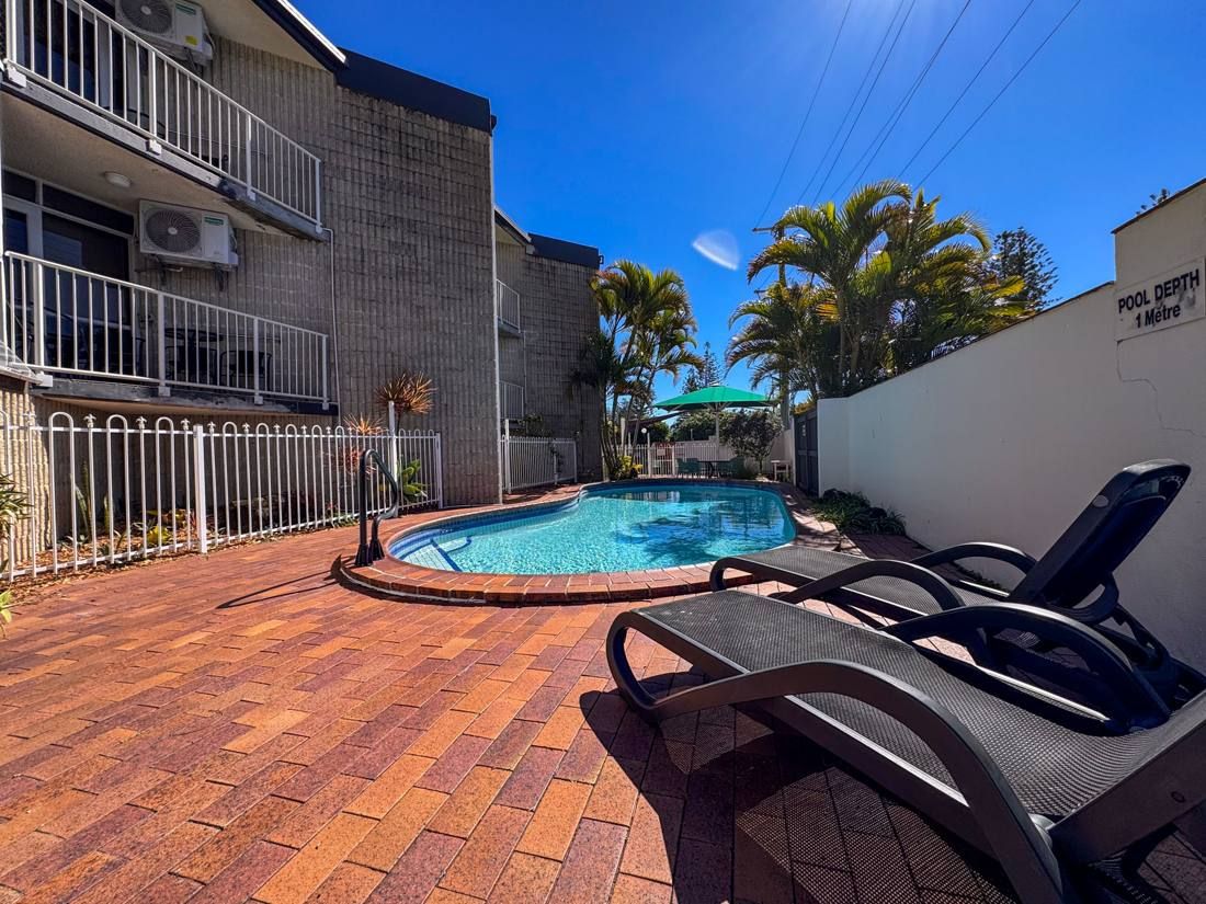 Poolside sun loungers beside the outdoor pool at Northpoint Apartments